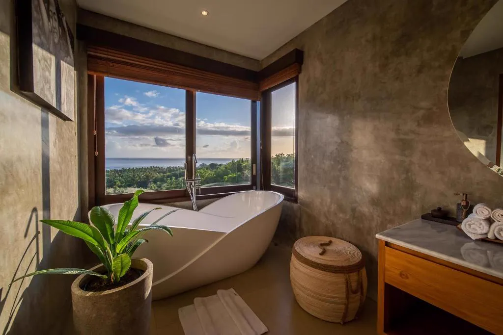 Freestanding bathtub by a window overlooking the sea