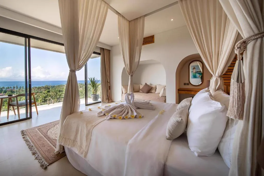 Canopy bedroom opening onto a balcony with a sea view